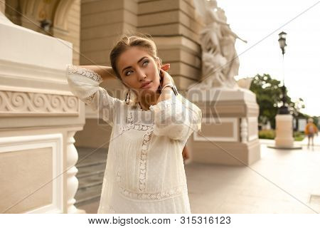 Tender Lady With Bronze Skin And Slim Sexy Body. Wearing Stylish White Dress And Accessories. Holdin
