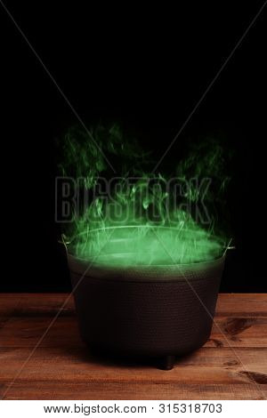 Black Halloween Cauldron With Green Smoke On Wood Table Top