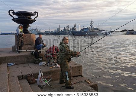 Saint-petersburg, Russia - July 23, 2019: Fishermen Catch Fish In Kronstadt, On The Background Of Wa