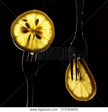 Collage Of Three Slices Of Lemons On The Fork On Dark Black Background. Silhouette Of A Fork In The 