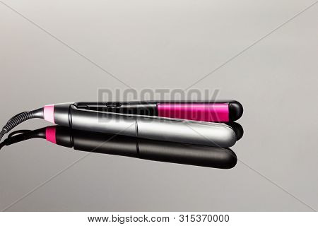 Electrical Hair Iron For Household On The Grey Mirror Background With Copy Space