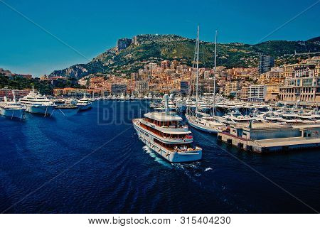 Monte Carlo, Monaco - December 08, 2009: Yacht Wedge Too W2 Go Into Sea Harbor With Houses On Mounta