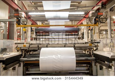 Huge industrial machine with rolled newly produced transparent polyethylene film