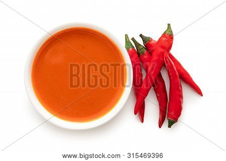 Peri Peri Chilli Sauce In A White Ceramic Bowl Next To A Pile Of Red Chillies Isolated On White From