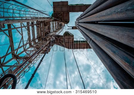 Oil And Gas Drilling Rig Onshore Dessert With Dramatic Cloudscape. Oil Drilling Rig Operation On The