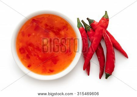 Sweet Chilli Sauce In A White Ceramic Bowl Next To A Pile Of Red Chillies Isolated On White From Abo