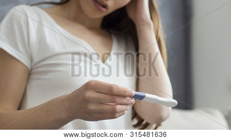Not This Time. Upset Woman Holding Pregnancy Test, Touching Her Head, Home Interior