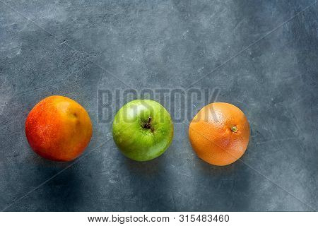 Ripe Juicy Seasonal And Tropical Fruits Mango Grapefruit Apple On Dark Stone Background. Healthy Pla