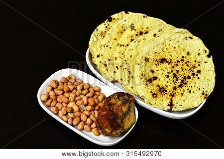 Roasted Papad An Indian Snack With Whole Peanuts And Jaggery In A Plate.