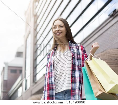 Pretty Young Woman Holding Colorful Paper Bags, Walking Down The Street, Copy Space