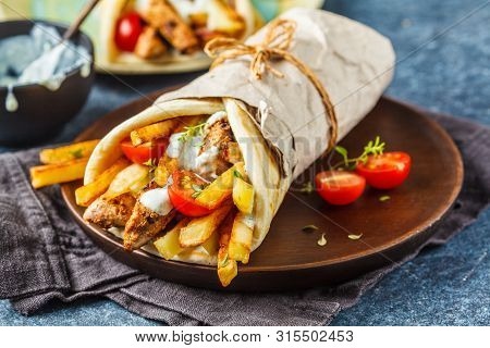 Gyros Souvlaki Wraps In Pita Bread With Chicken, Potatoes And Tzatziki Sauce, Blue Background.