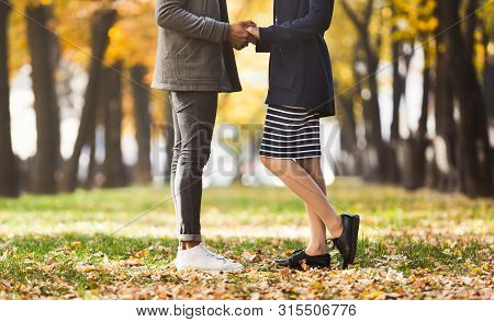 Male And Female Legs During Date In Autumn Park, Side View