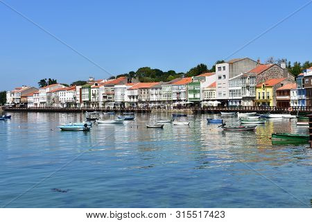 Mugardos, Spain. August 2, 2019. Small Fishing Village With Boats And Colorful Houses. Blue Sky, Sun