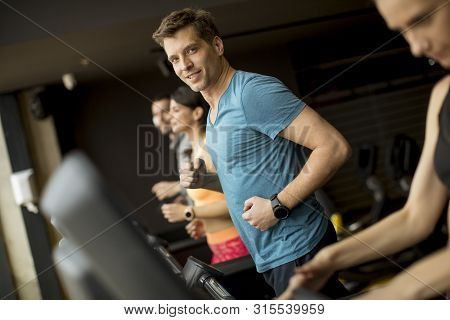 Young People Using Threadmill In Modern Gym