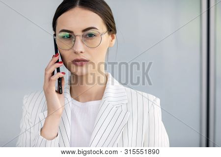 Business Woman With Phone Near Office. Portrait Of Beautiful Smiling Female In Fashion Office Clothe
