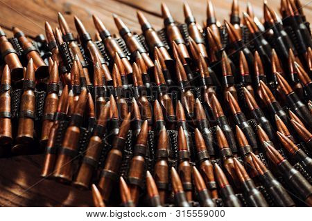 Bullets On A Wooden Background. Military Concept.