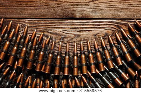 Bullets On A Wooden Background. Military Concept.