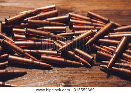 Bullets On A Wooden Background. Military Concept.