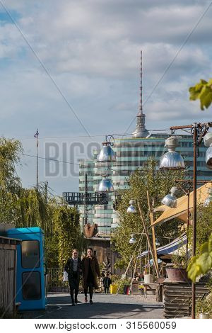 Berlin, Germany - September 26, 2018: Contrasting Upwards Perspective Of Girls Walking Among A Natur