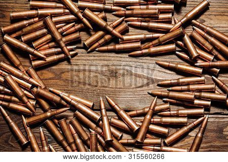 Bullets On A Wooden Background. Military Concept.