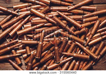Bullets On A Wooden Background. Military Concept.