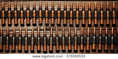 Bullets On A Wooden Background. Military Concept.