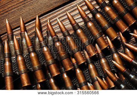 Bullets On A Wooden Background. Military Concept.