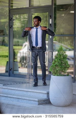 Handsome African American Businessman In Suit Looking Away While Standing Near Office Building