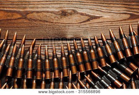 Bullets On A Wooden Background. Military Concept.