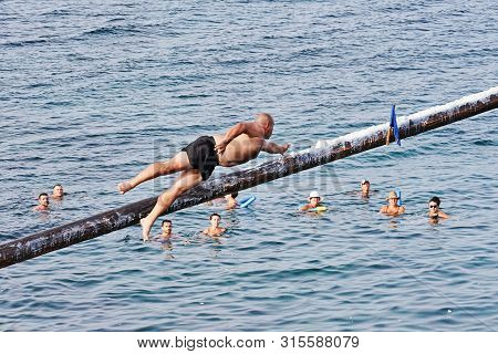 Xghajra, Malta - August 3, 2019: Traditional Maltese Game Of Gostra, Where Is Brave Local Men Would 