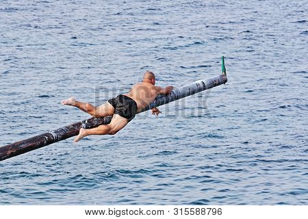 Xghajra, Malta - August 3, 2019: Traditional Maltese Game Of Gostra, Where Is Brave Local Men Would 