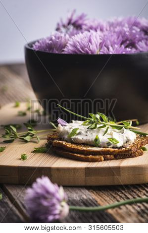 A Delicious Garlic And Chive Cream Cheese Spread On Herbed Crackers Next To A Bowl Of Purple Chive F