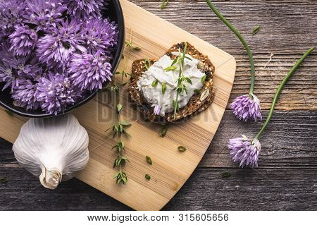 A Delicious Garlic And Chive Cream Cheese Spread On Herbed Crackers Next To A Bowl Of Purple Chive F