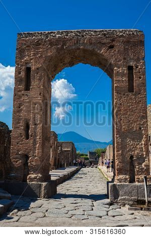 Pompeii, Italy - April, 2018: Tourists At The Arch Of Caligula In The Ancient City Of Pompeii