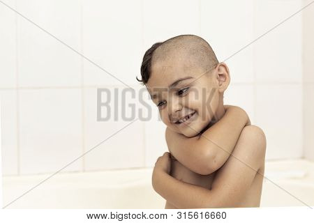 Six-year Boy At Haircutting At Home. Father Cut Half Of The Son's Hair Off At The Bathroom