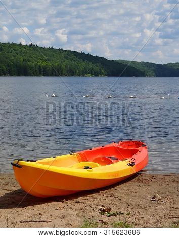 Kayak Resting On Sandy Beach Of A Beautiful Lake On Sunny Summer Day. La Peche Lake Quebec  Canada