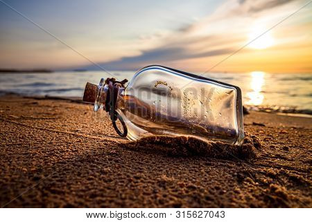 Message in the bottle against the Sun setting down