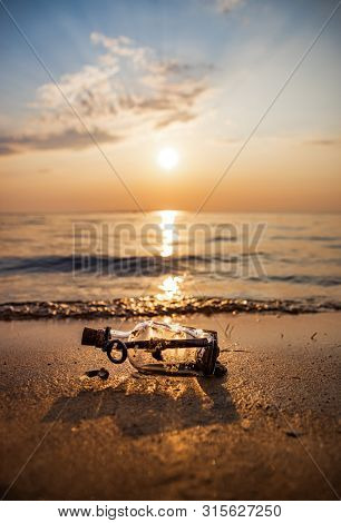 Message in the bottle against the Sun setting down