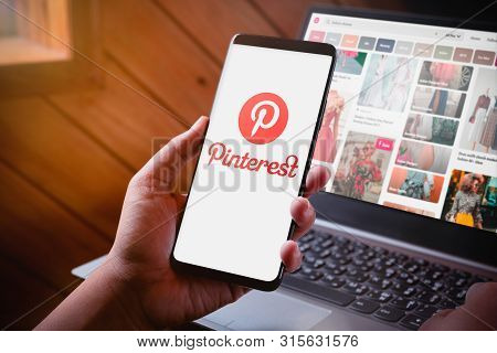 Bangkok, Thailand - August 6, 2019: Hands Holding Smartphone With Pinterest Logo Screen And Pinteres