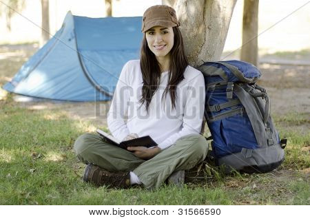 Joven, escribir en un diario de viaje
