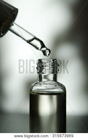 Cosmetic Or Medical Glass Bottle With Pipette. Skin Care Concept. Natural Hard Light, Deep Shadows. 