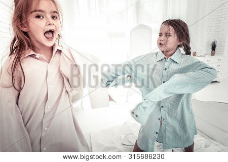 Happy Smiling Kids Jumping On The Bed In Fahers Shirts