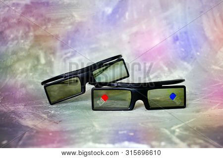 Two Plastic 3 D Glasses Lie On Each Other Onon The Colorful Background, With