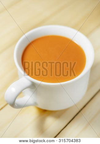 Hot Milk Tea In A White Cup On Wooden Background