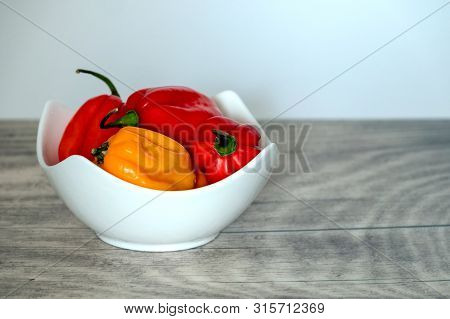 Habanero Pepper In A White Bowl On A Wooden Plate.