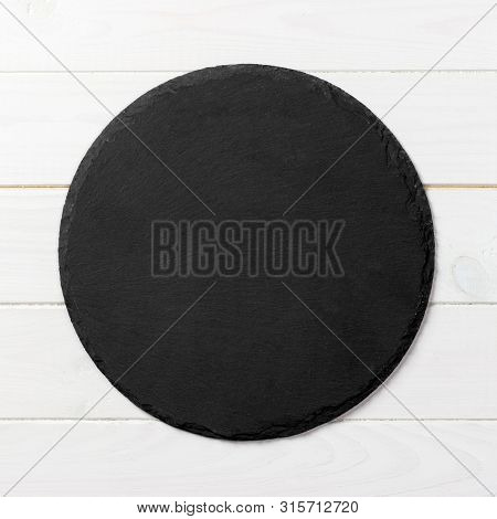 Black Round Plate On Wooden Background, Top View, Copy Space