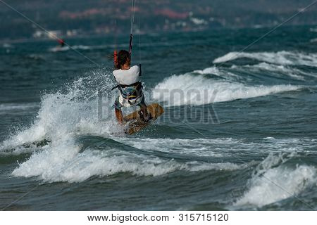 Kitesurfing on the waves of the sea in Mui Ne beach, Phan Thiet, Binh Thuan, Vietnam. Kitesurfing, Kiteboarding action photos Kitesurfer In action