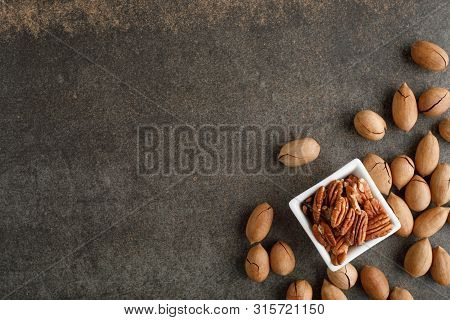 Frame Of Pecan Nuts On Marble Background. Square Bowl Of Nuts In The Corner