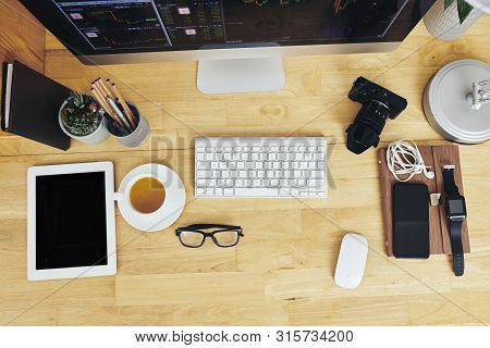 Gadgets, Cup Of Tea And Glasses On Wooden Desk Of Office Worker, View From Above
