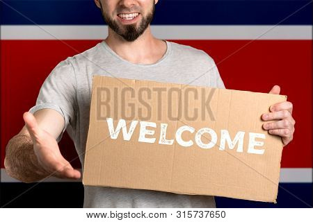 The Concept Of Tolerance For Immigrants And People Of Different Life Positions. A Man Holds A Cardbo